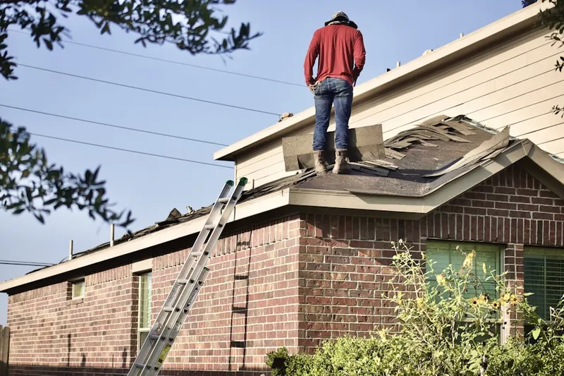 Professional roofer working on a residential roof in Amsbry